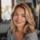 Jeune femme souriante aux cheveux blonds chez elle.
